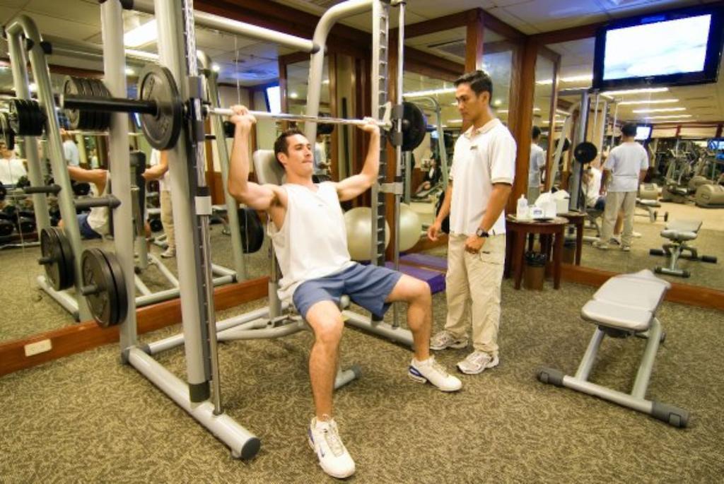 Marco Polo Davao Exterior foto A personal trainer assisting a client with a weight training exercise